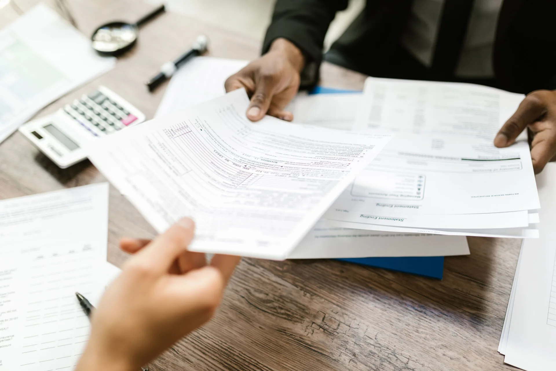 Claim documents being handed across a desk during a legal consultation